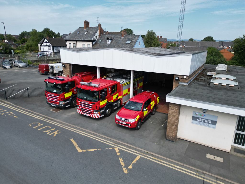 Fire station with three fire vehicles taken from above with crew carrier at front