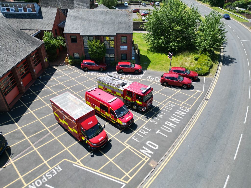 Three fire vehicles and car fleet taken from above