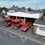 Fire station with three fire vehicles taken from above with crew carrier at front