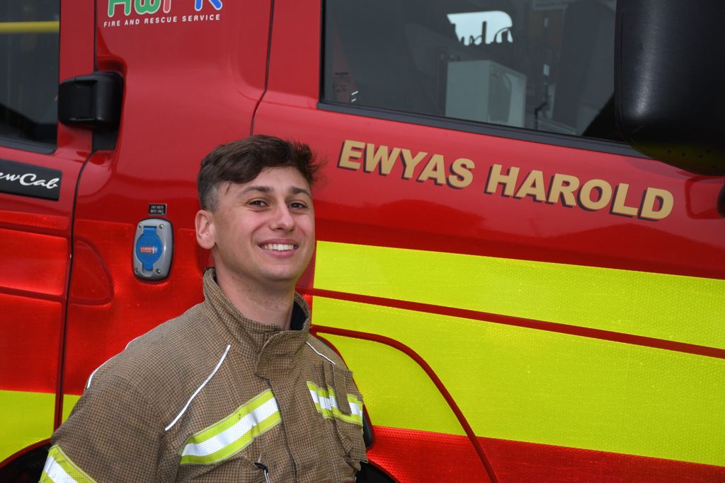 Firefighter standing in front of a fire engine.