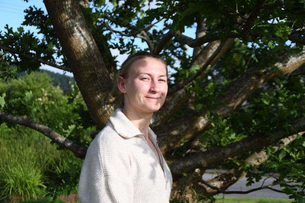 firefighter in her own clothes next to a tree