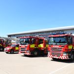 Line up of fire vehicles with fire engine in foreground