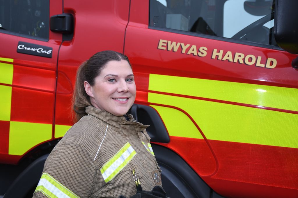 Firefighter standing in front of fire engine