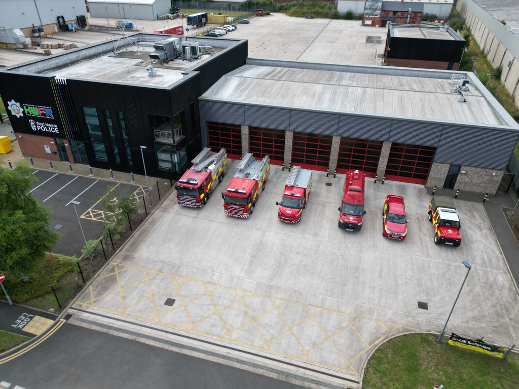 Line up of six vehicles at front of fire station taken from above