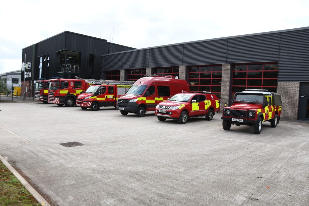 6 vehicles at front of station, Land Rover in foreground