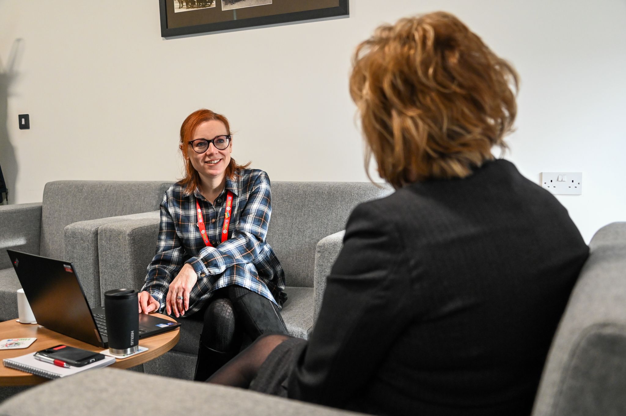 Two members HR team talking by a computer